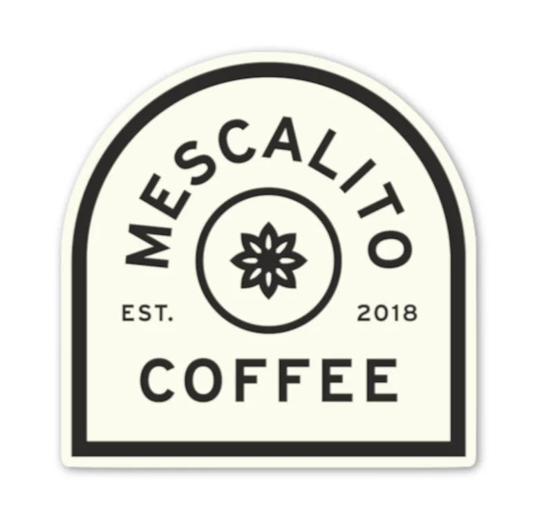The Shop Stickers from Mescalito Coffee feature a black and white logo with a central flower, “MESCALITO COFFEE,” and “EST. 2018” in a rounded rectangle—evoking classic small town and timeless coffee shop style.